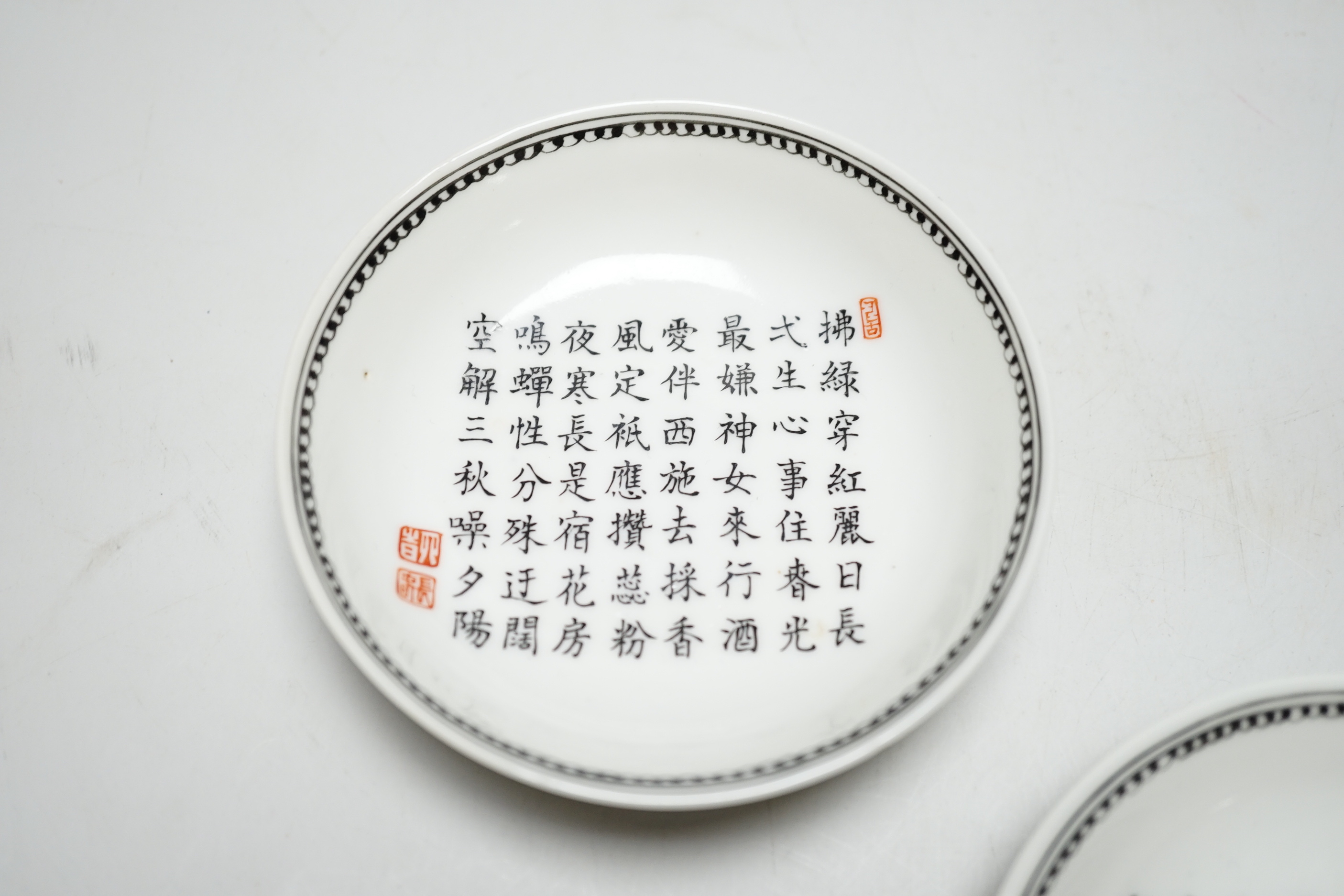 A pair of Chinese calligraphic enamelled porcelain saucers, 9.5cm